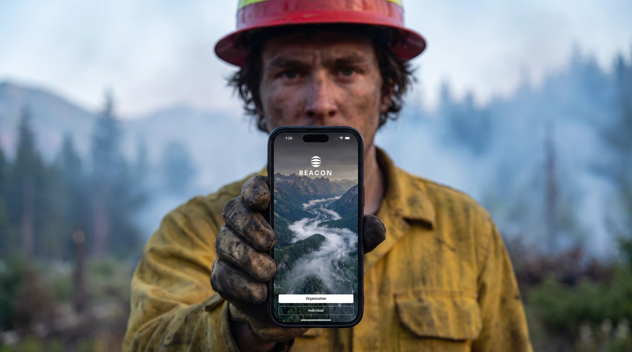 A wildland firefighter holding a phone displaying Beacon in the field.