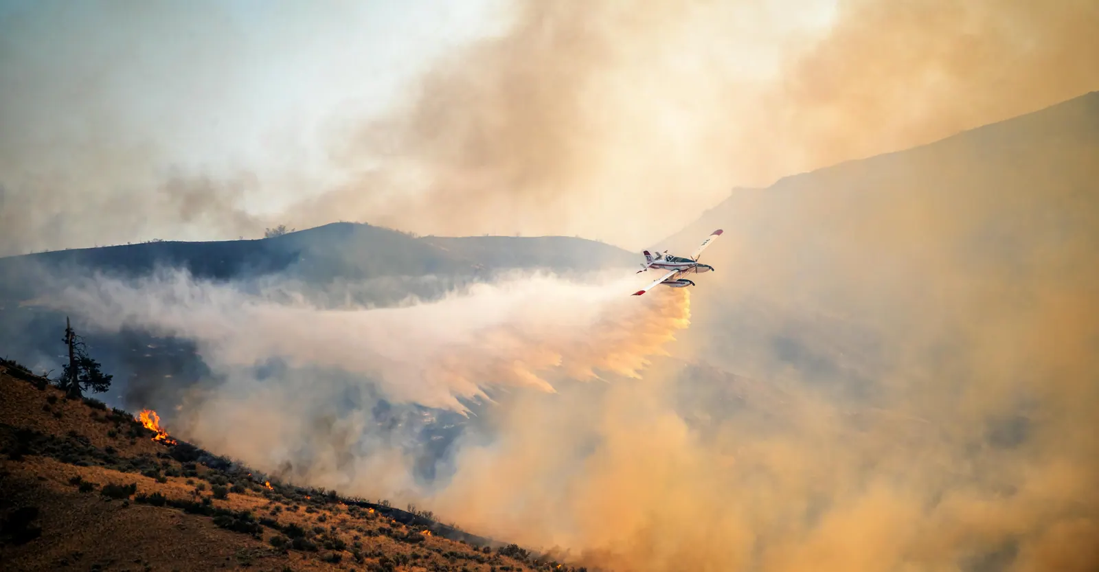 Air tanker deploying retardant over a fire